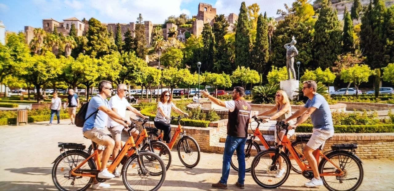 Grupo de personas en bicicleta en un espacio urbano soleado